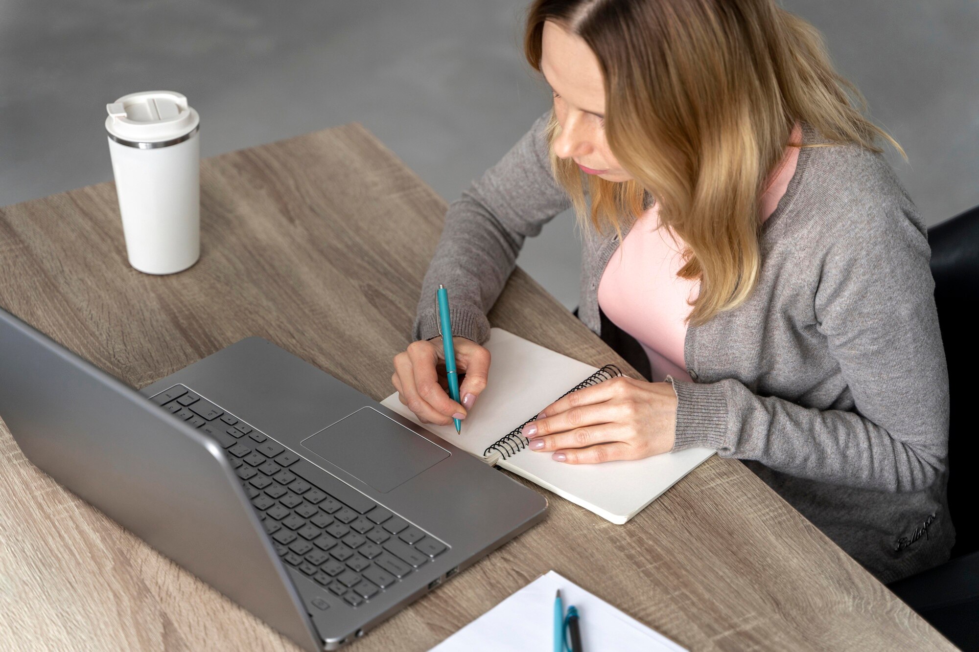 Coaching individuel femme travail cahier ordinateur et café