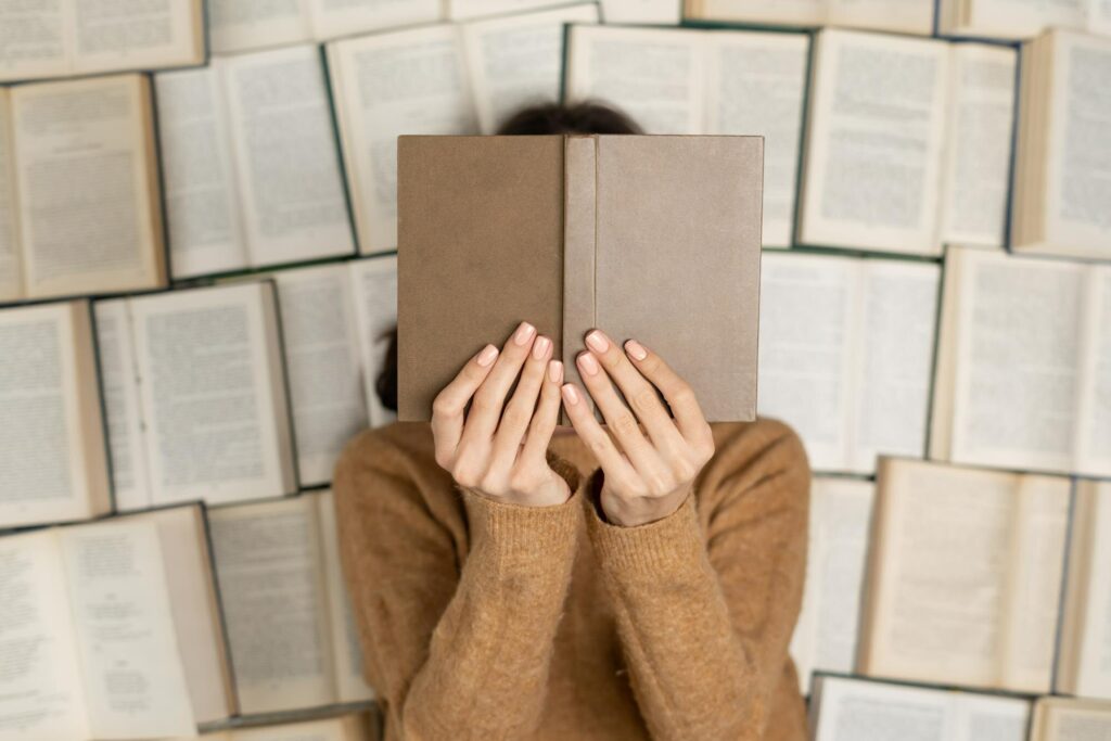 femme cachée derriere un livre ouvert