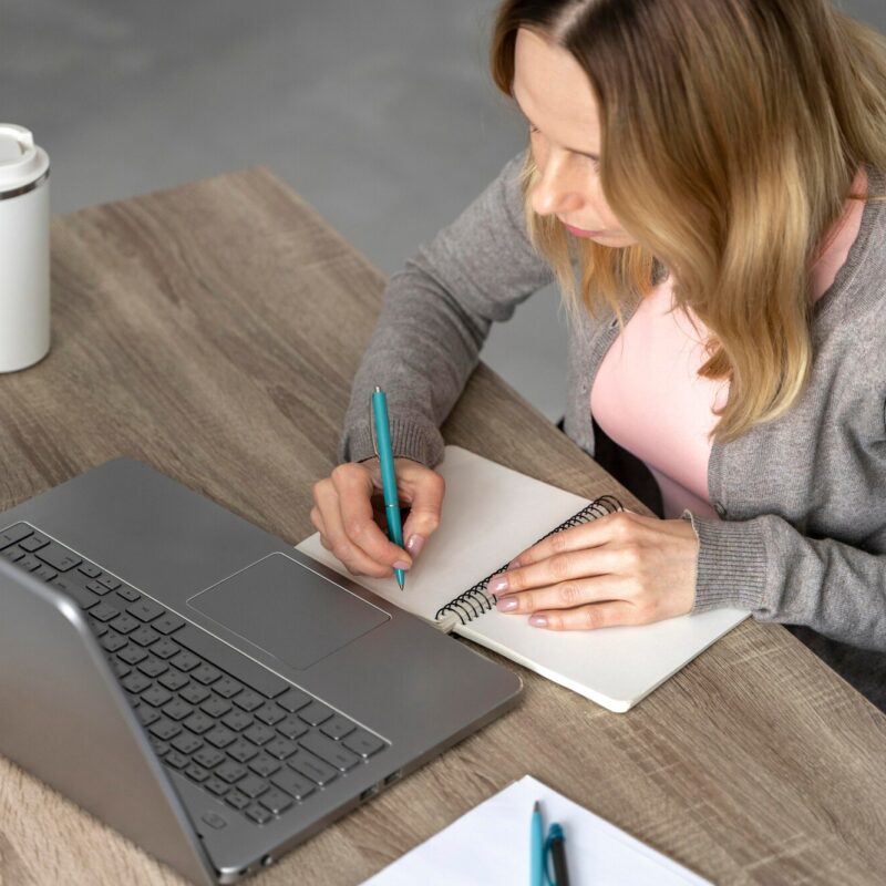 Coaching individuel femme travail cahier ordinateur et café